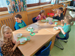 Kinder+sitzen+am+Tisch+und+essen